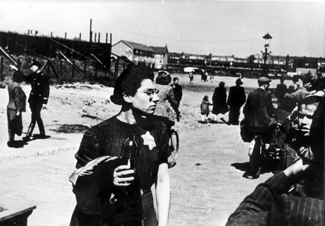 Bilden visar närbild på kvinna med judestjärna fäst på vänster sida och människor i bakgrunden.