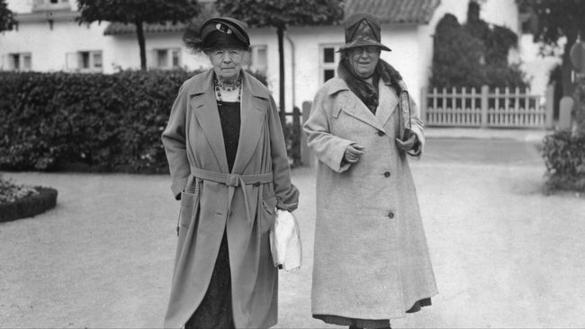 Bilden visar två äldre kvinnor som står bredvid varandra utomhus.
