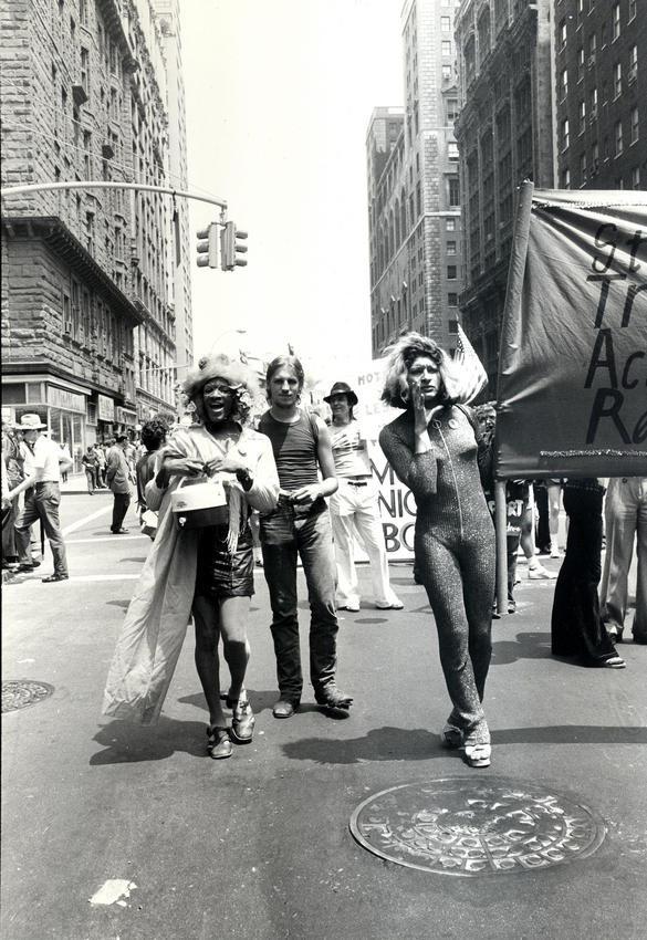 Bilden visar människor som går i en demonstration och håller upp en banderoll.