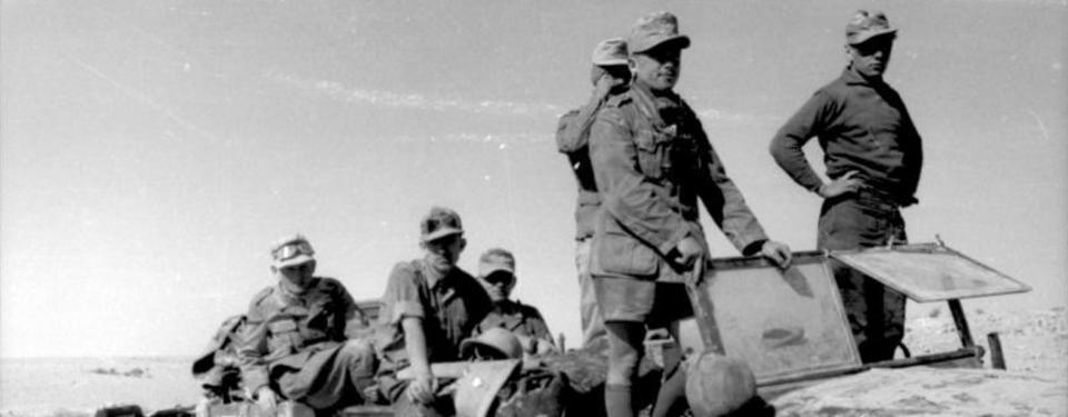 Bilden visar sex soldater ovanpå ett militärfordon.