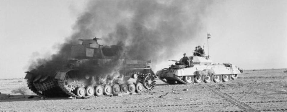 Bilden visar en stridsvagn med soldater som passerar rökhärjad stridsvagn. 