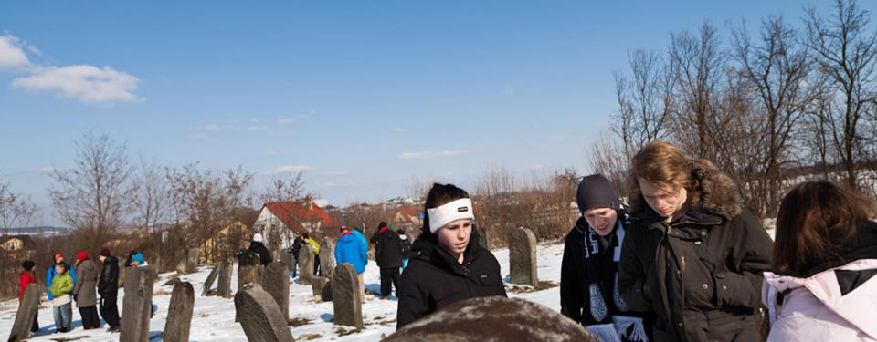 Bilden visar skolungdomar på en begravningsplats.