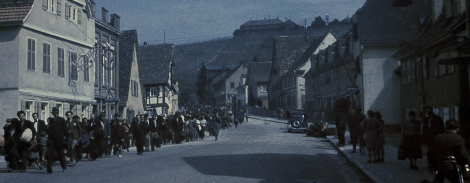 Bilden visar människor i lång kö på en gata.