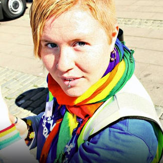 Bilden visar en person med en regnbågsfärgad halsduk.
