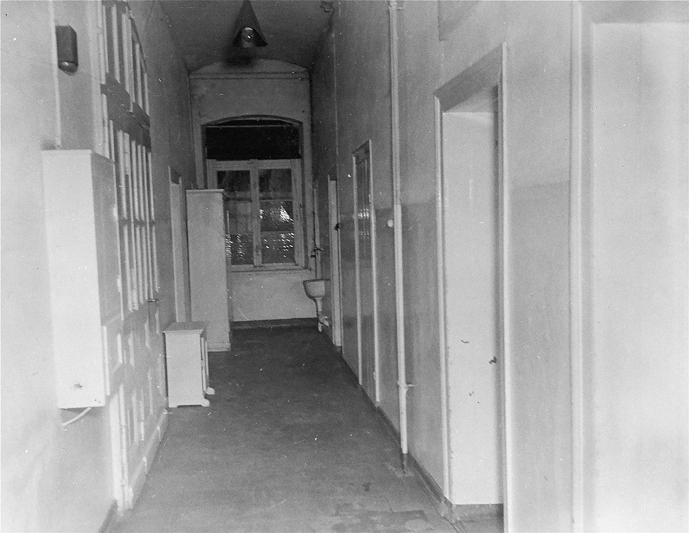 Bilden visar en tom och ödslig korridor med flera dörrar.