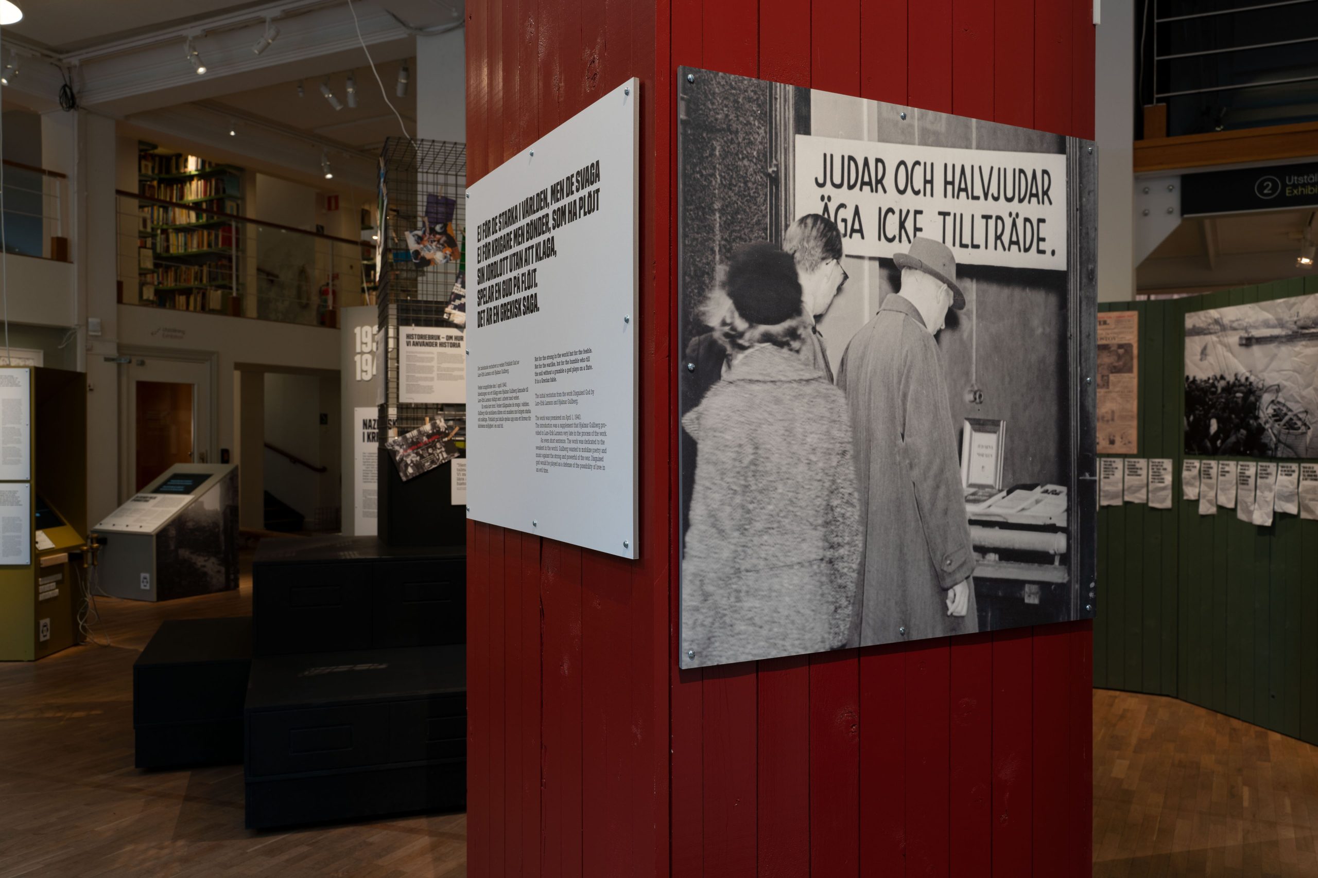 En pelare i en utställningslokal. På pelaren sitter ett svartvitt foto visande ett skyltfönster med texten "judar och halvjudar äga icke tillträde"
