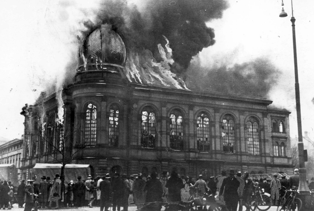 Bilden visar en synagoga där eldslågor och rök kommer ut ur fönster och tak.