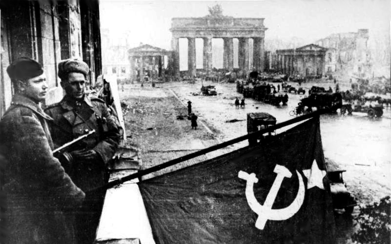Bilden visar Sovjetiska soldater som hissar sin fana över paradgatan Unter den Linden i Berlin.