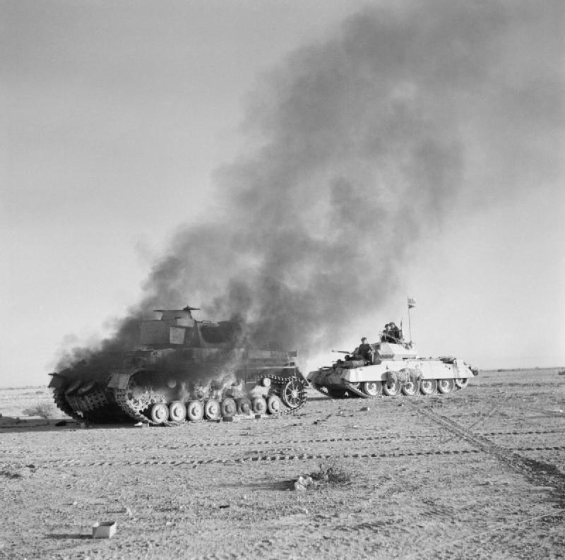 Bilden visar en stridsvagn med soldater som passerar rökhärjad stridsvagn.