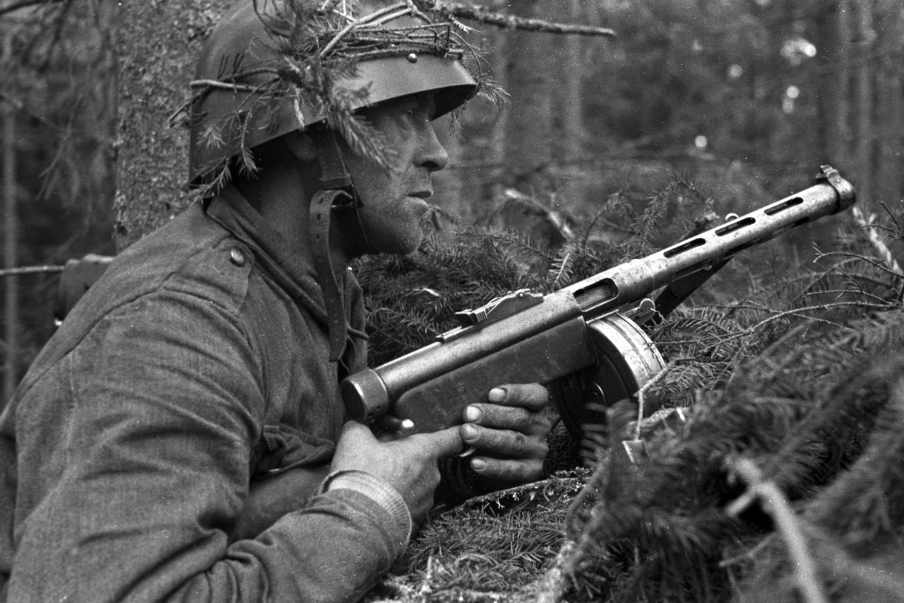 Soldat med hjälm och gevär i skogen.