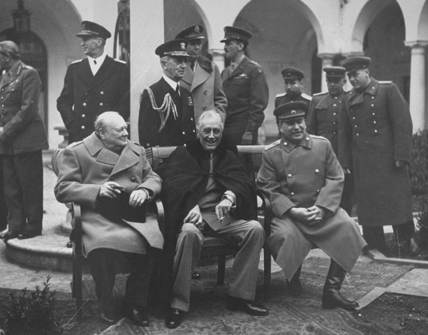 Bilden visar Churchill, Roosevelt och Stalin sittandes framför militärer.