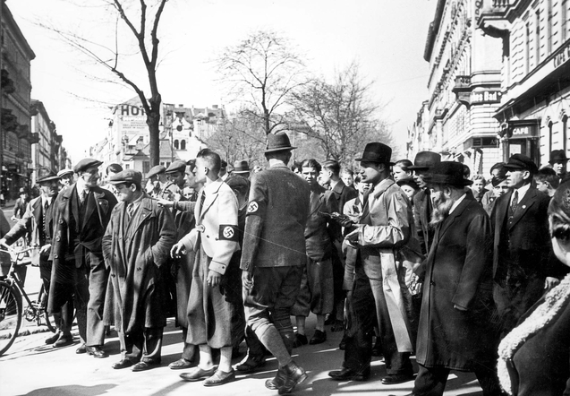 Bilden visar en samling män i kostym på gata, några med armbindel med svastika.