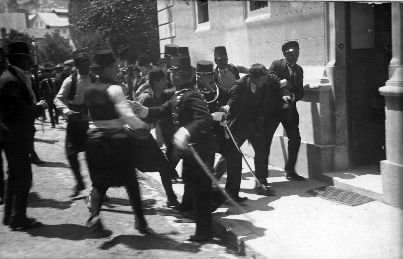 Bilden visar människor på en gata som bråkar med polis.