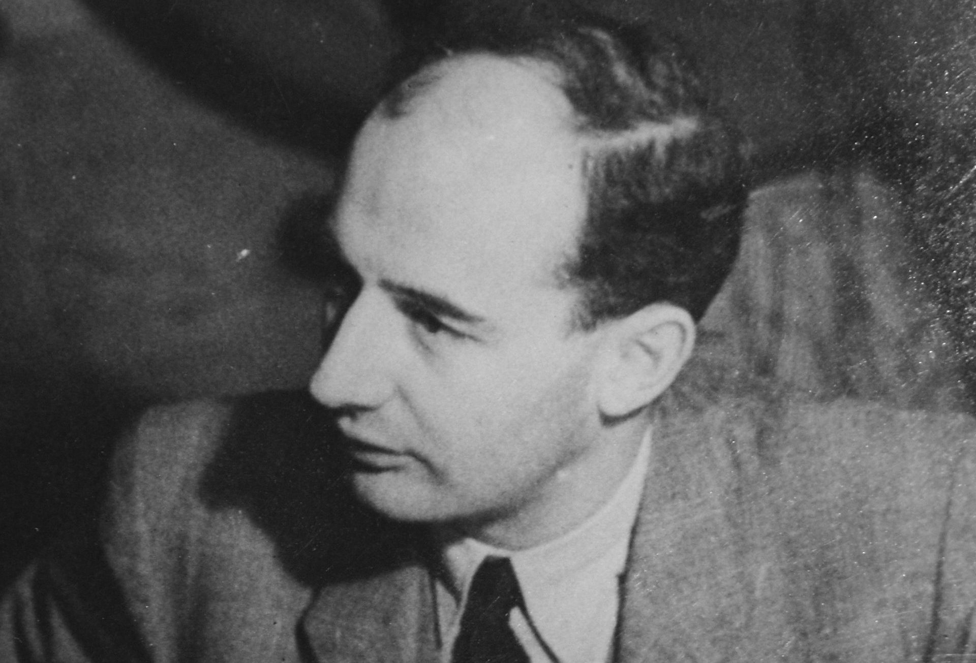 Porträtt av Raoul Wallenberg iklädd kostym som tittar på något utanför bild.