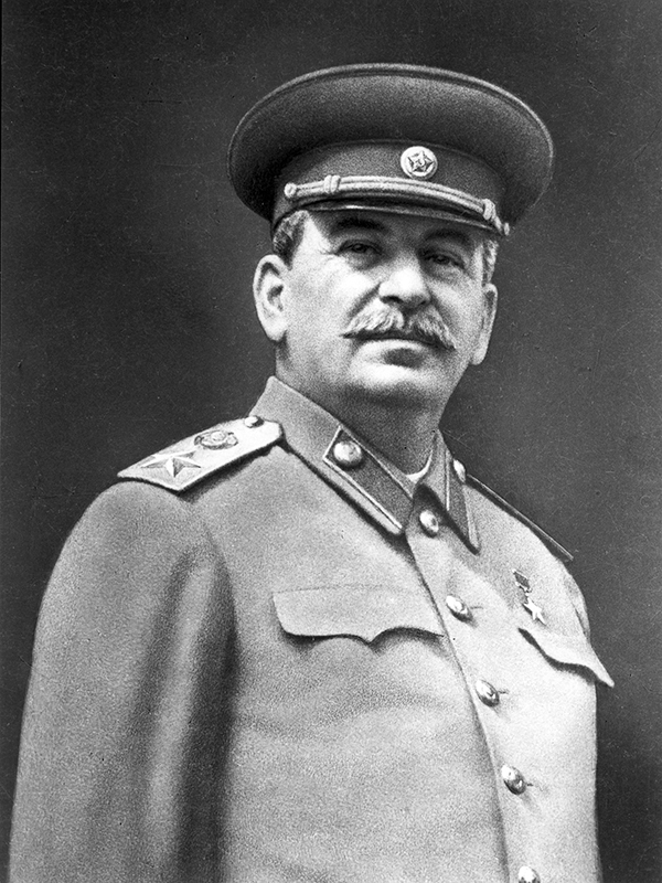 Ett svartvit porträttfoto av en man med mustasch klädd i uniform och huvudbonad.