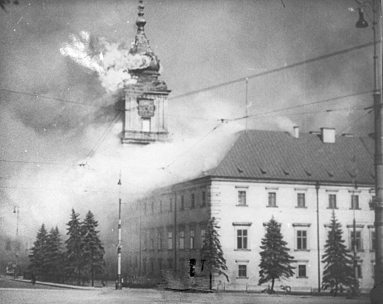 Bilden visar ett hustak med rök från samt ett klocktorn i eldslågor och rök.