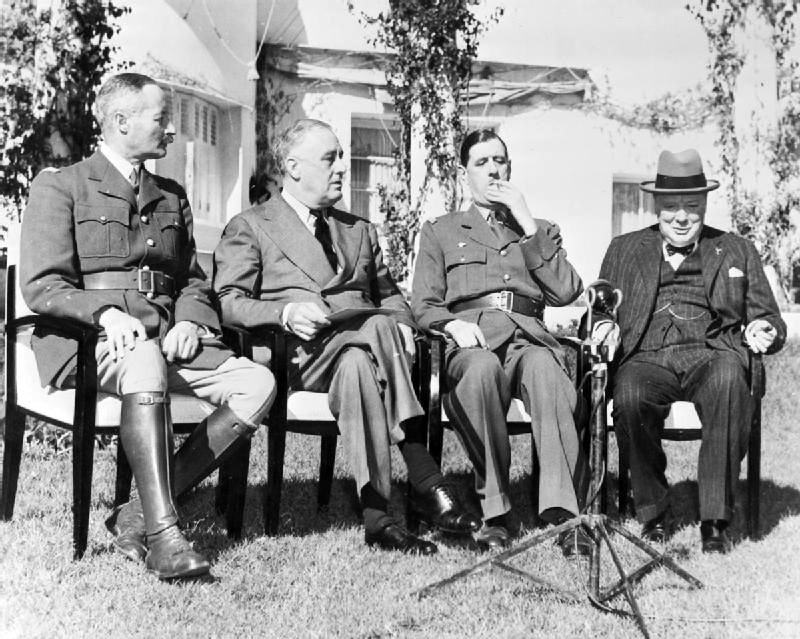 Bilden visar 4 män som sitter uppradade på stolar.