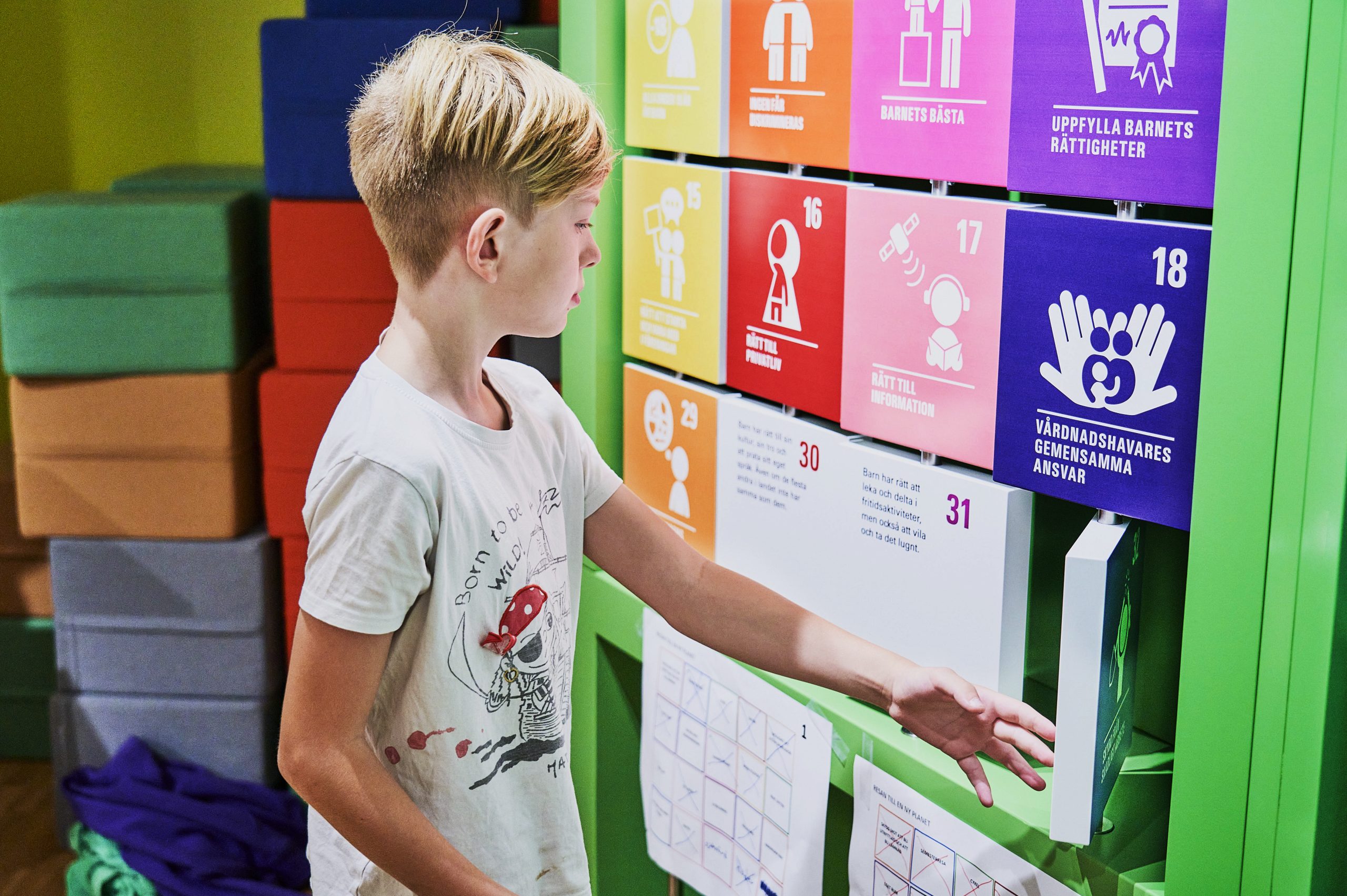 En pojke i tioårsåldern vänder på en av flera färgglada skyltar.