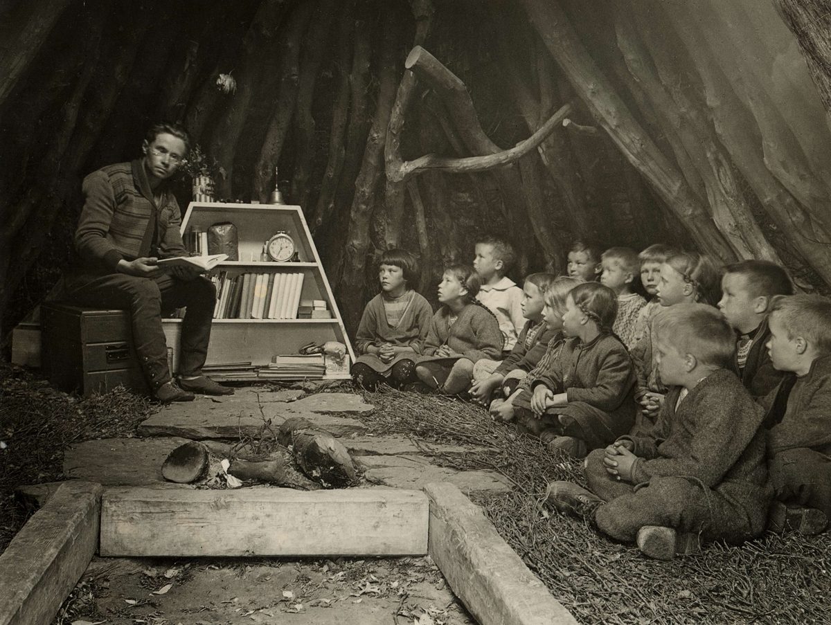 En nomadskola där läraren sitter på en stol och eleverna på golvet i en kåta.