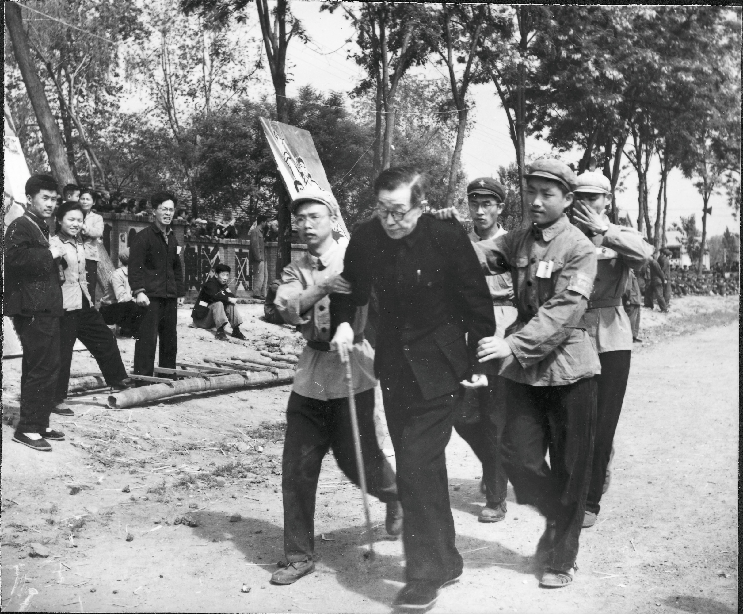 En man leds fram på gatan av några unga soldater