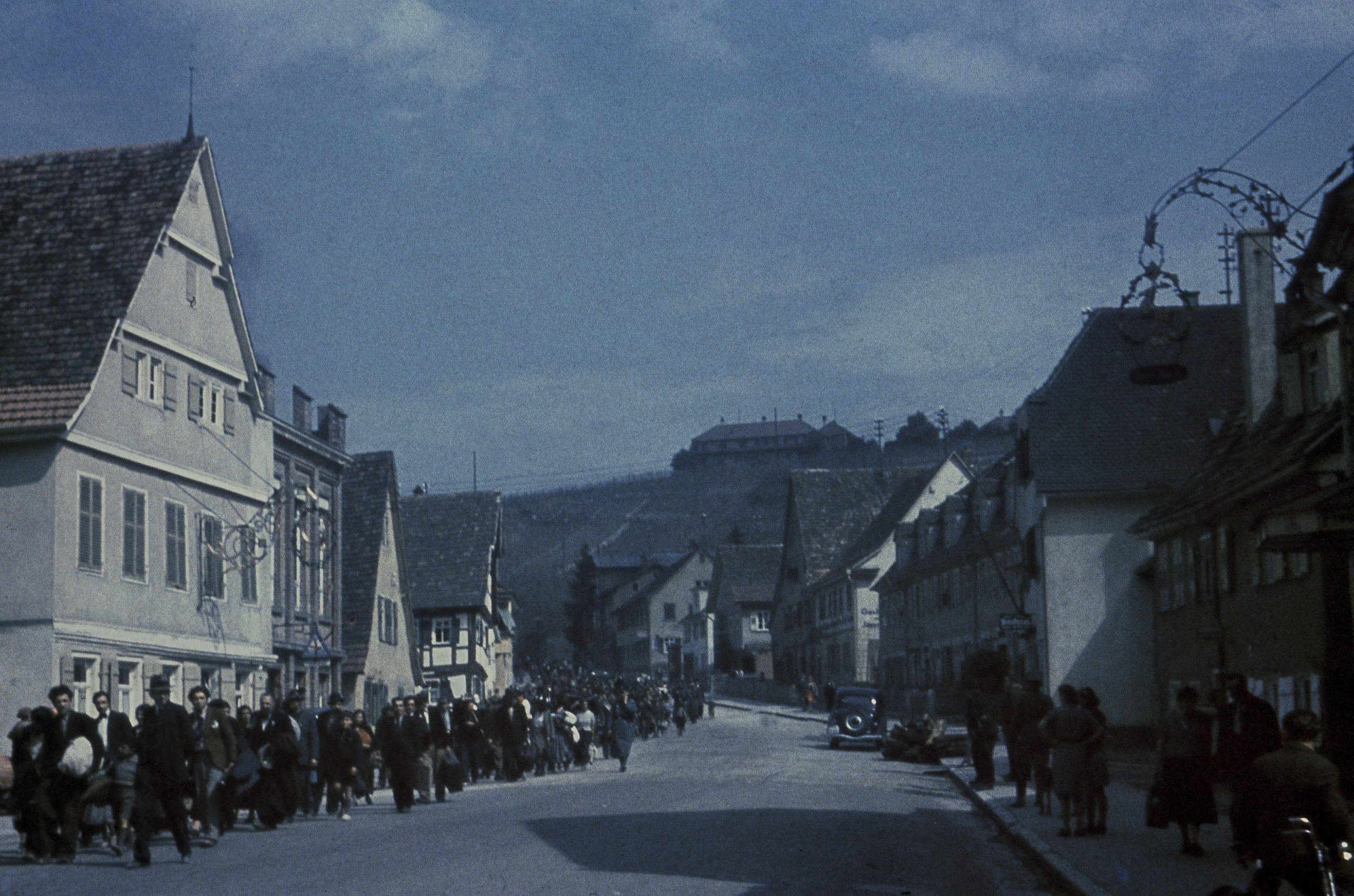 Bilden visar människor i lång kö på en gata.