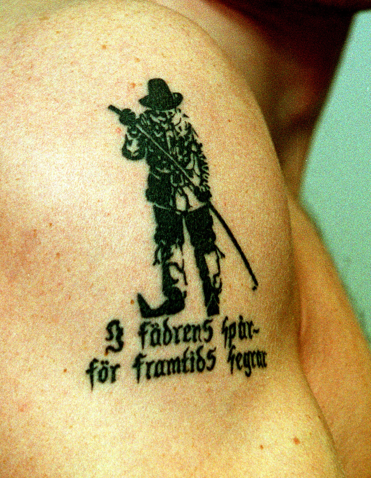Bilden visar en tatuering med texten "I fädrens spår - för framtids segrar".