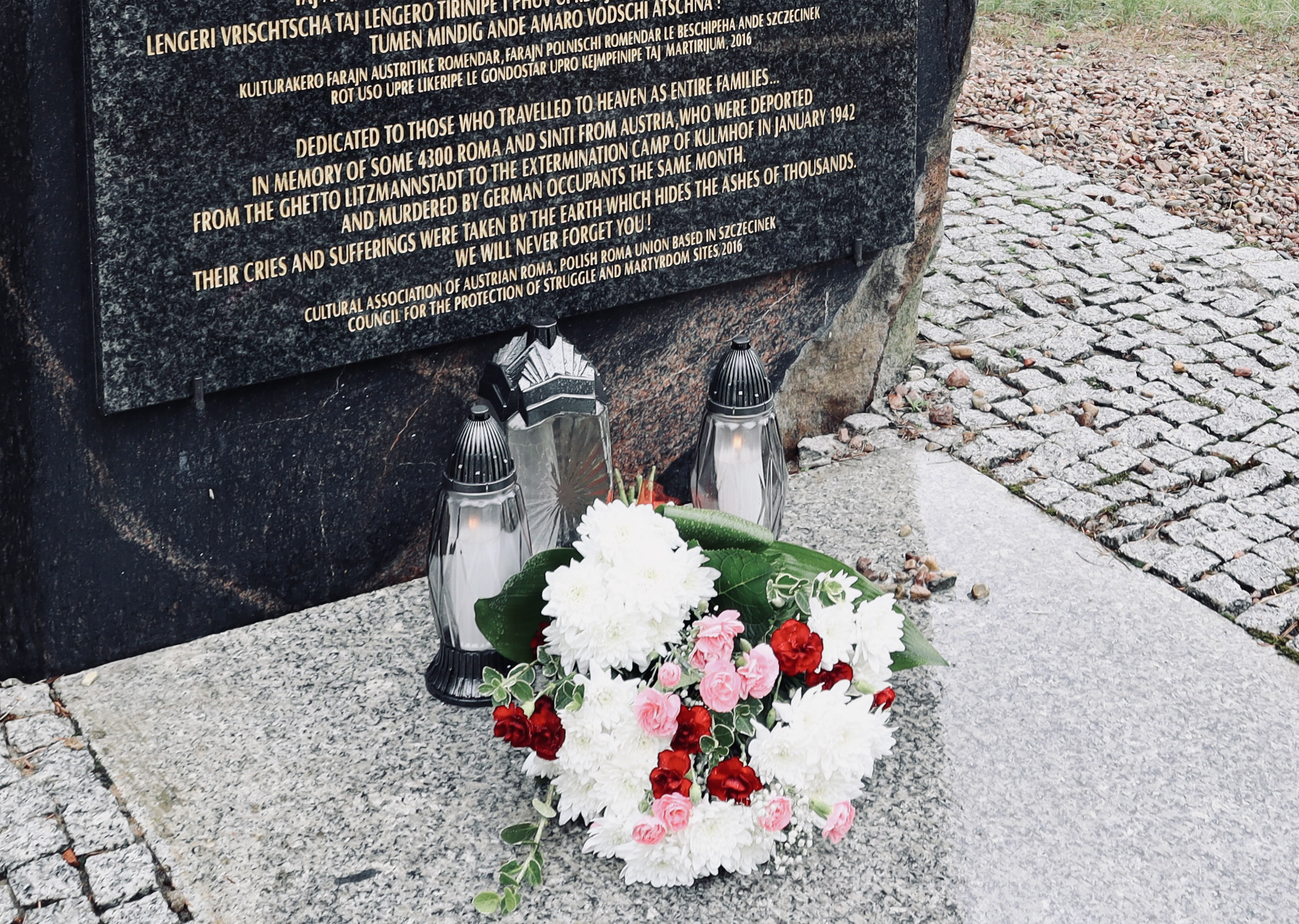 En minnessten med blommor framför.