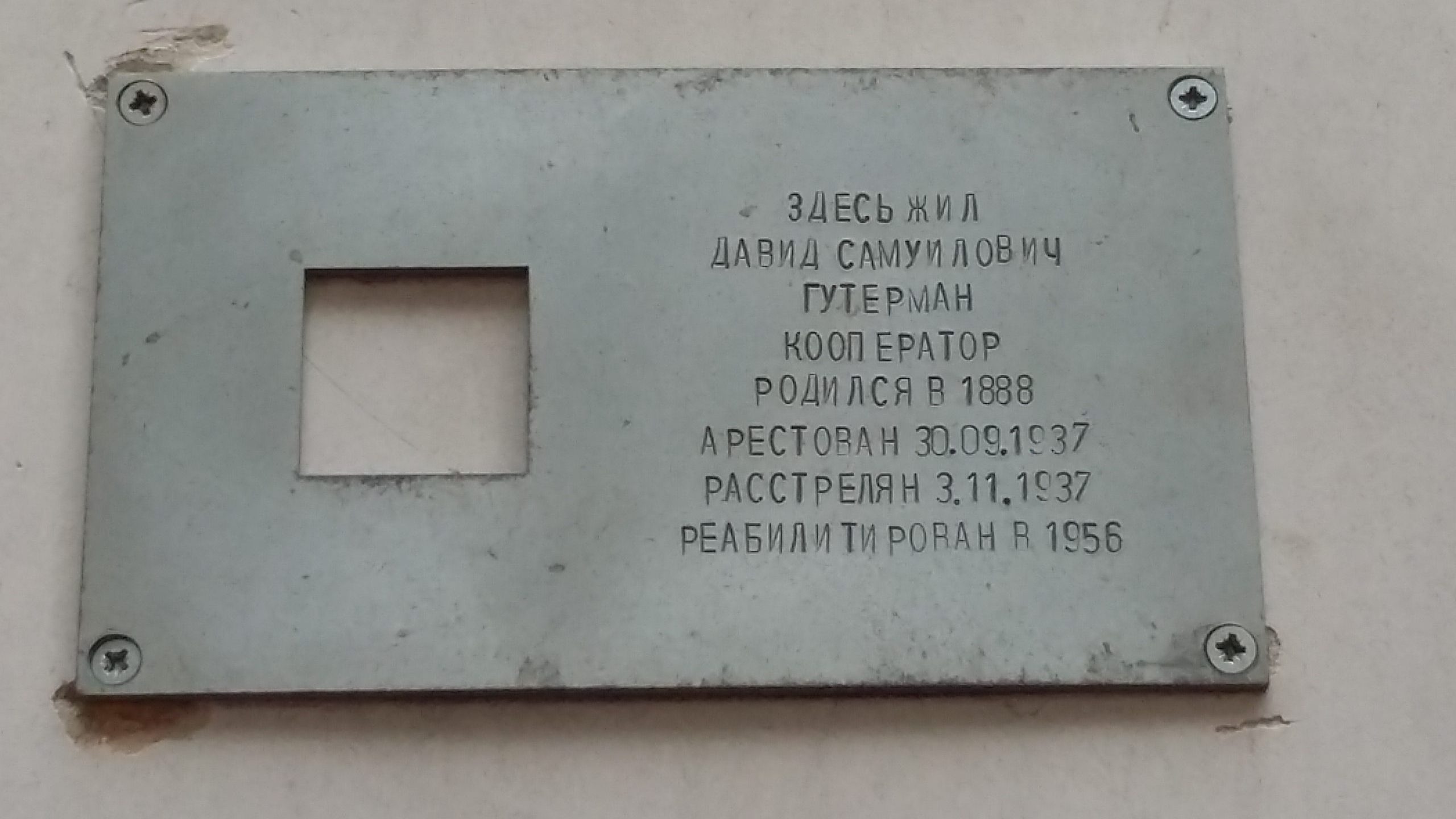 En metallskylt med ingraverad text på ryska.