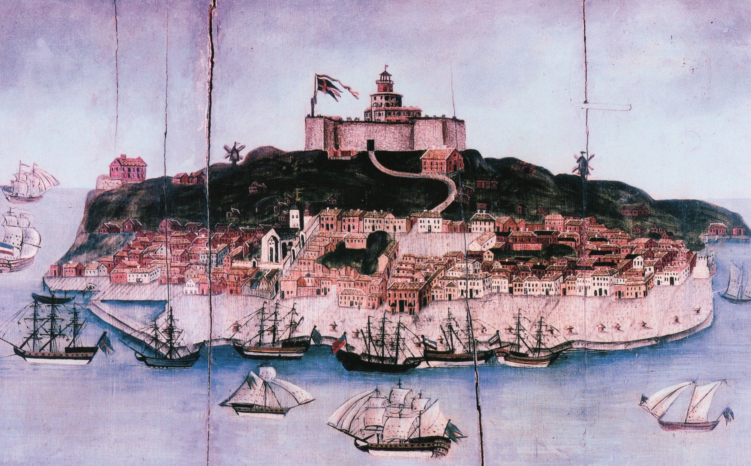 Äldre målning på trä. Målningen föreställer en ö med ett fort längst upp på ön. I vattnet runt ön syns segelfartyg.