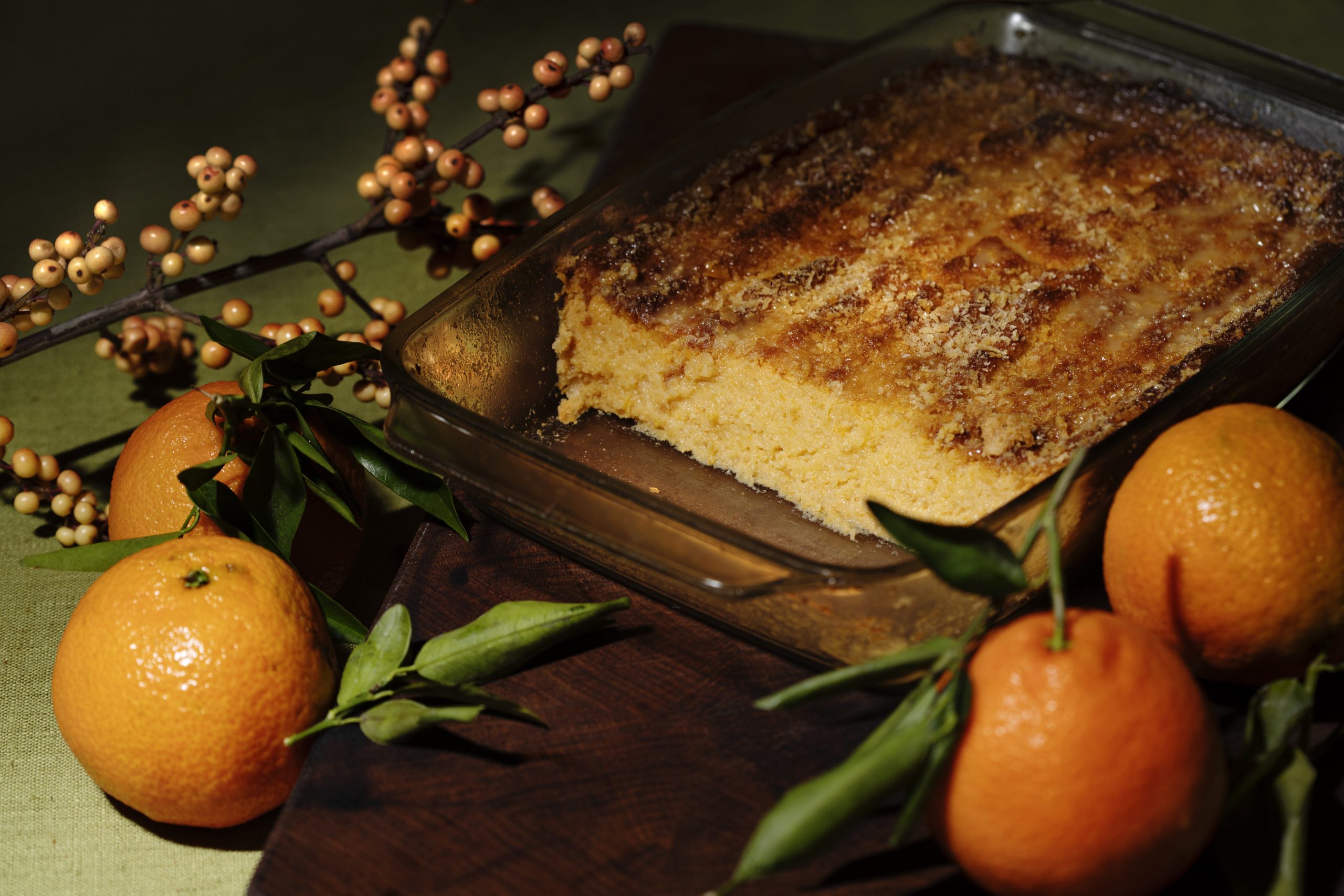 En ugnsform med någon form av mat. Bredvid ligger apelsiner.