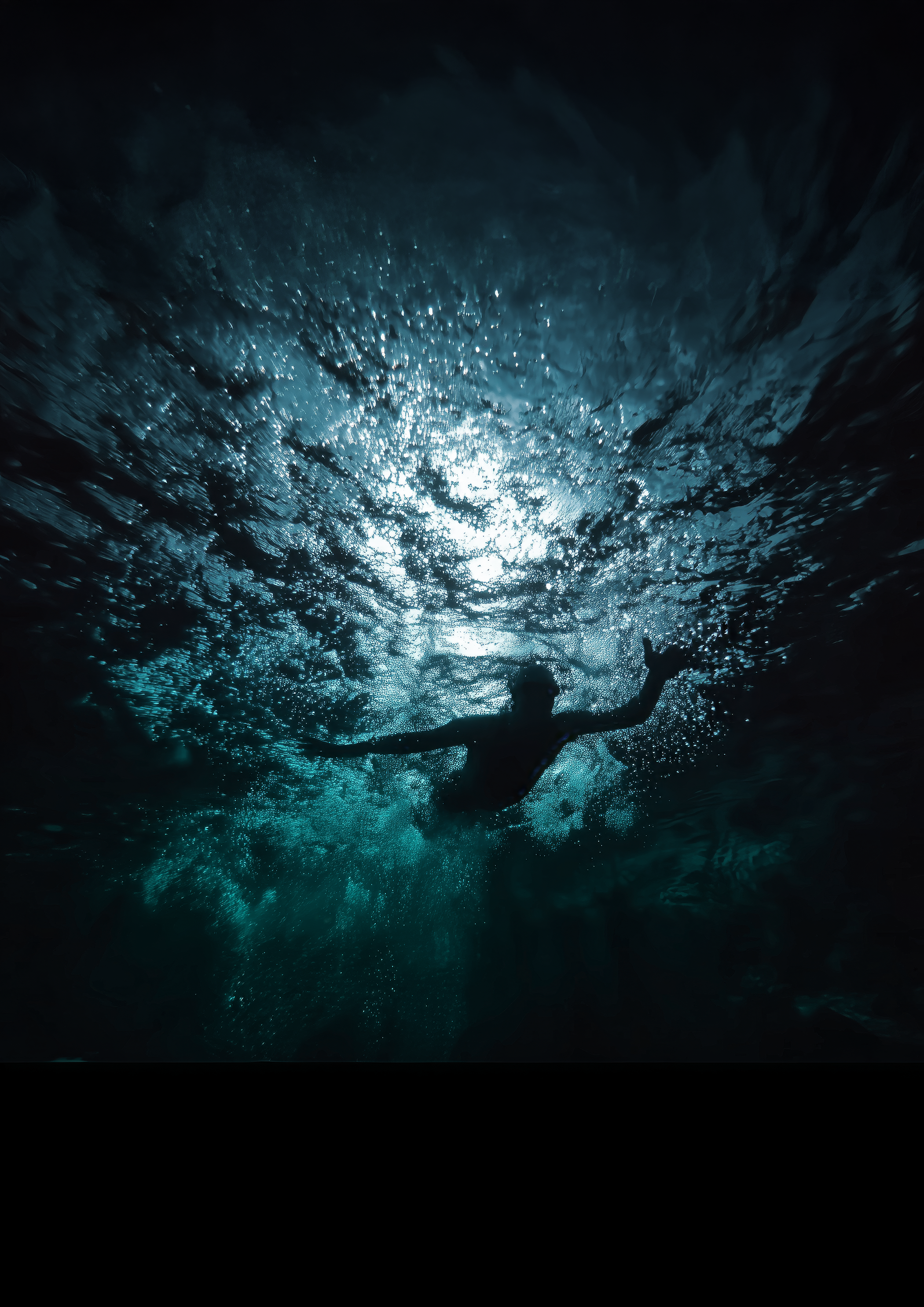 En simmare betraktad underifrån. Havet runt simmaren är mörkt och ödligt.