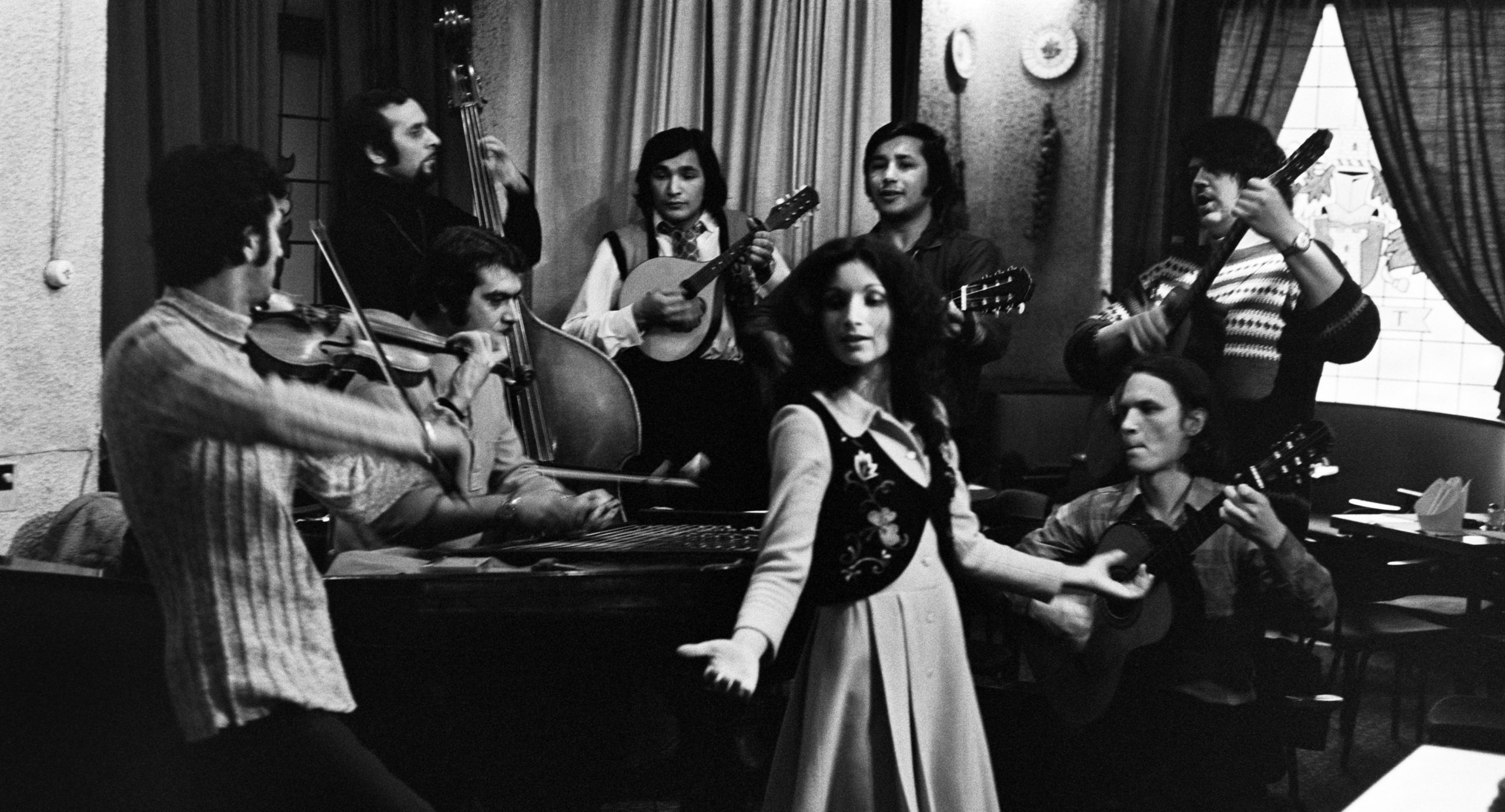 Svartvitt foto av ett 8-mannaband som spelar. Bland instrumenten finns fiol och kontrabas.