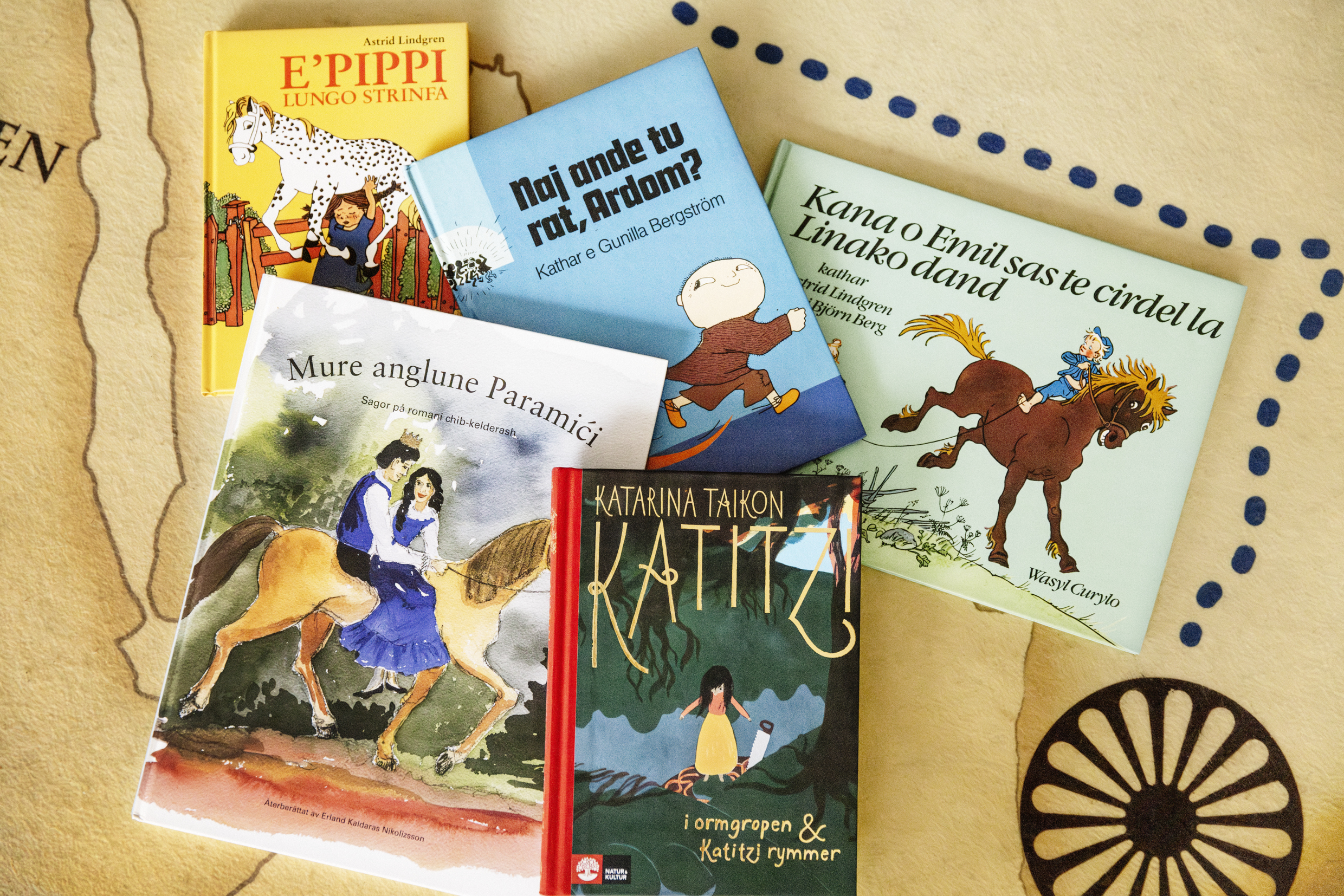 En samling färgglada barnböcker ligger utspridda på ett bord.