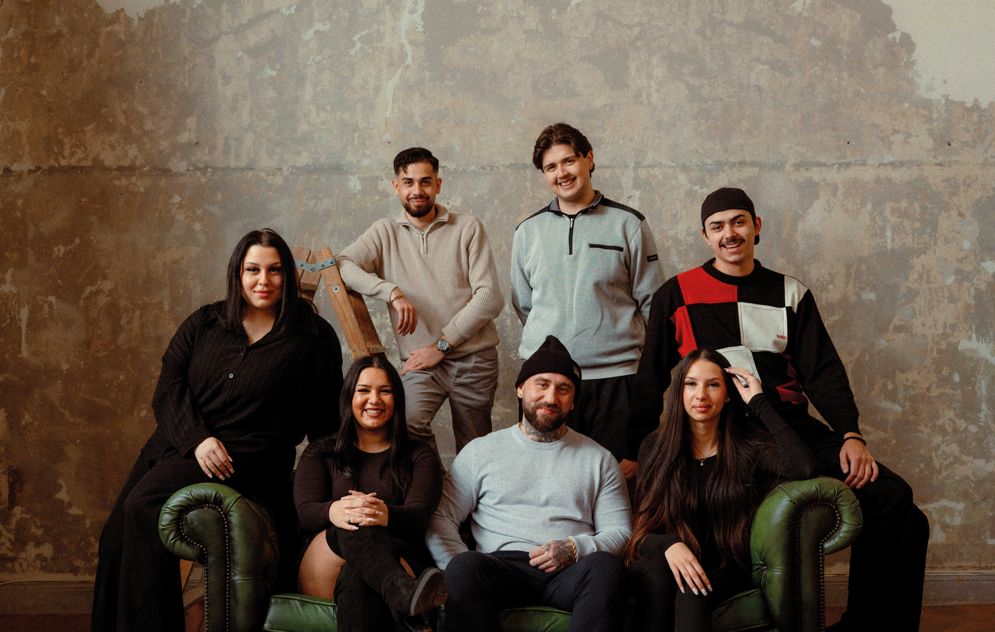 Sju människor samlade i en soffa.